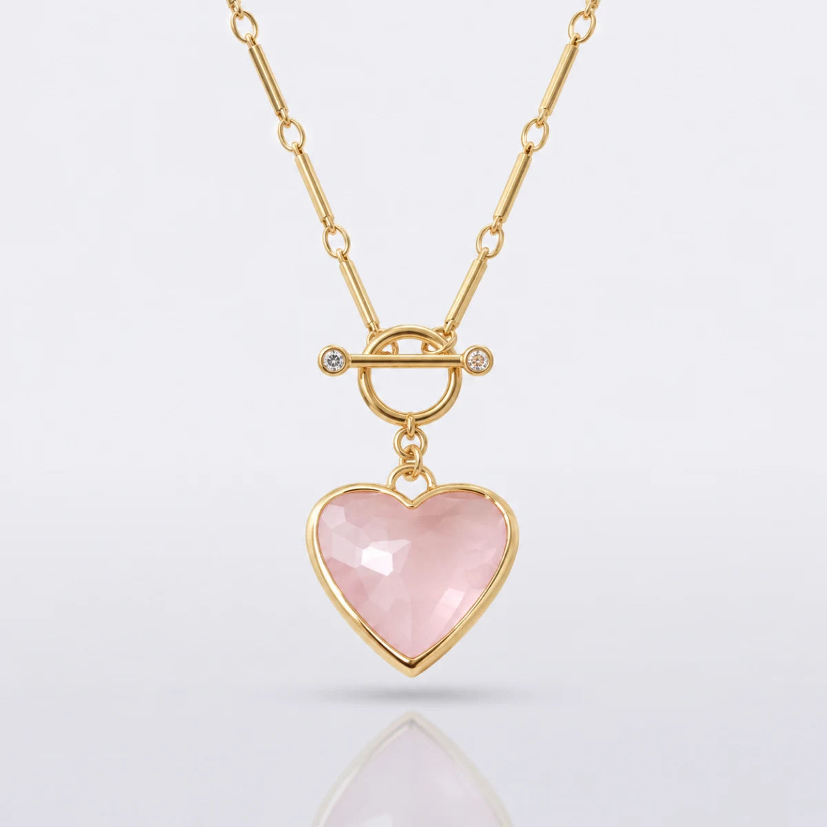 Pink faceted heart pendant and gold chain detail